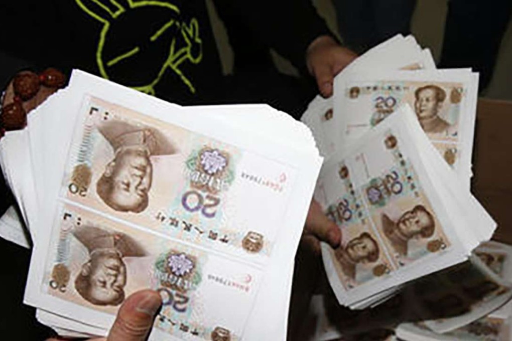 A police officer displays sheets of forged banknotes. Photo: SCMP Pictures