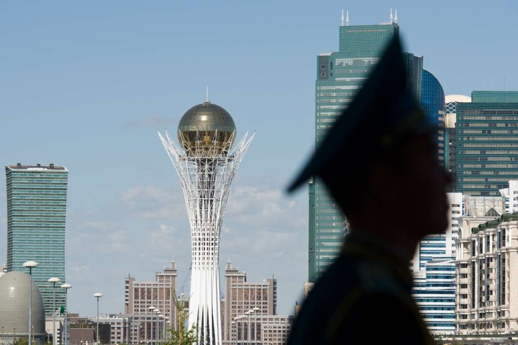 The Byterek tower is visible in the centre of Astana as a soldier stands guard outside the Presidential Palace. Photo: AFP