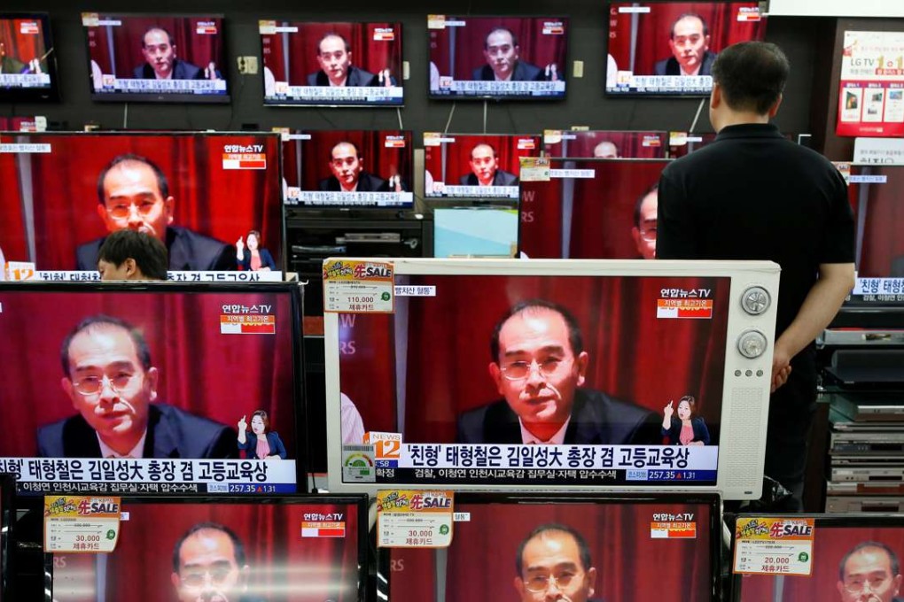 A sales assistant watches TV sets broadcasting a news report on Thae Yong Ho, North Korea's deputy ambassador in London, who has defected with his family to South Korea. Photo: Reuters