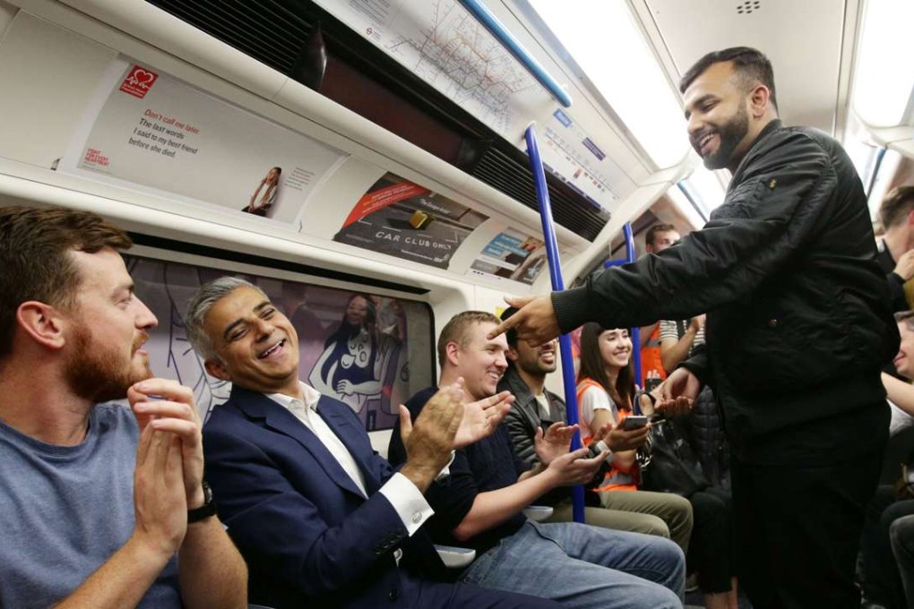 London Mayor Sadiq Khan (second left) applauds poet Hussain Manawer after he recited his poem The Night Tube. Photo: Reuters