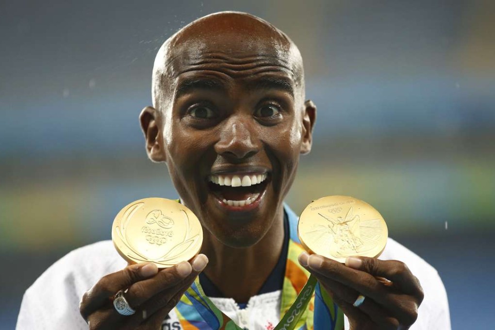 Mo Farah poses with his gold medals on the podium after winning the men's 5000m final. Photo: EPA