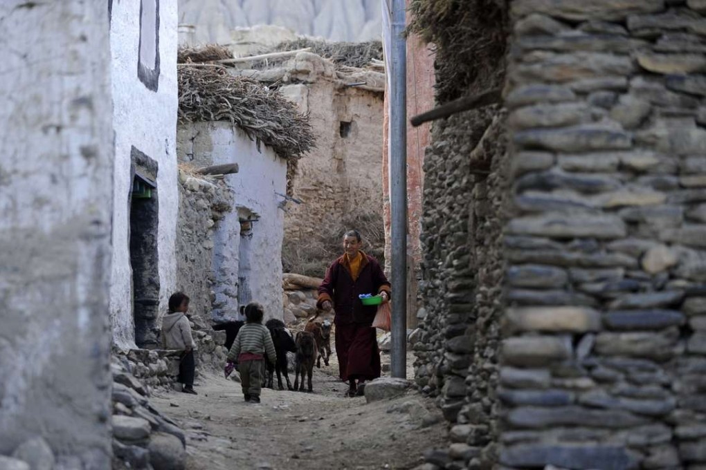 A Buddhist monk walking past children in Ghemi Village in Upper Mustang, north-west of Kathmandu. Photo: AFP