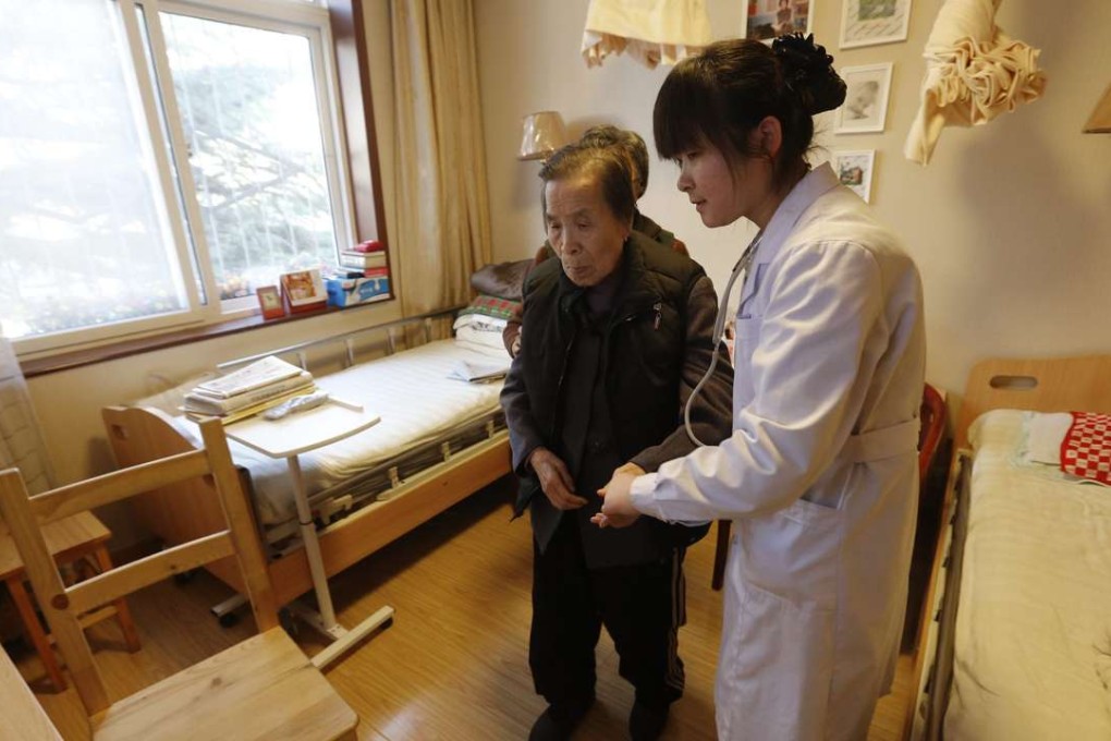 A nurse helps a senior citizen at the Cun Cao Chun Hui retirement facility in Beijing. In 2015, China had 222 million people aged above 60. Photo: EPA