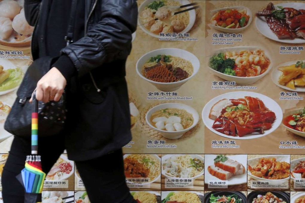 A passer-by walks outside a restaurant in Hong Kong. Photo: Reuters