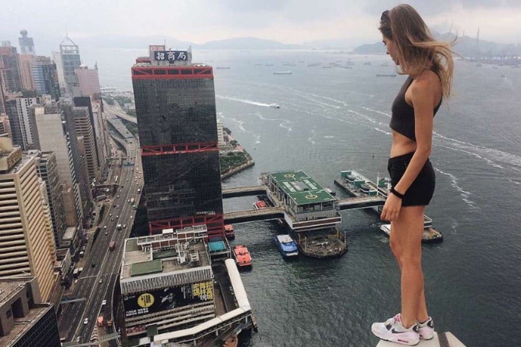 Angela Nikolau on the edge of a building in Central, looking towards the Shun Tak Centre.