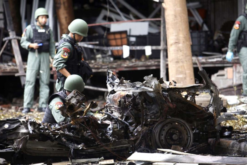 Thai bomb squad officers examine the wreckage of a car after an explosion outside a hotel in Pattani province, southern Thailand. Photo: AP