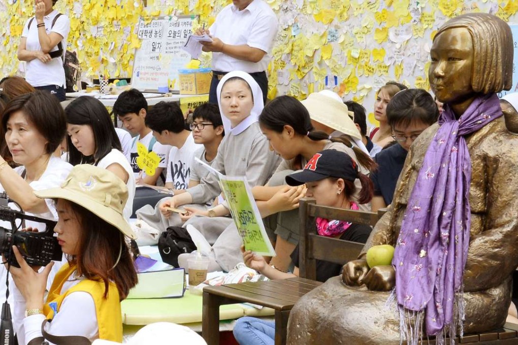 Activists gather around a statue of a girl in front of the Japanese Embassy in Seoul that symbolises the so-called comfort women on August 24. Photo: Kyodo