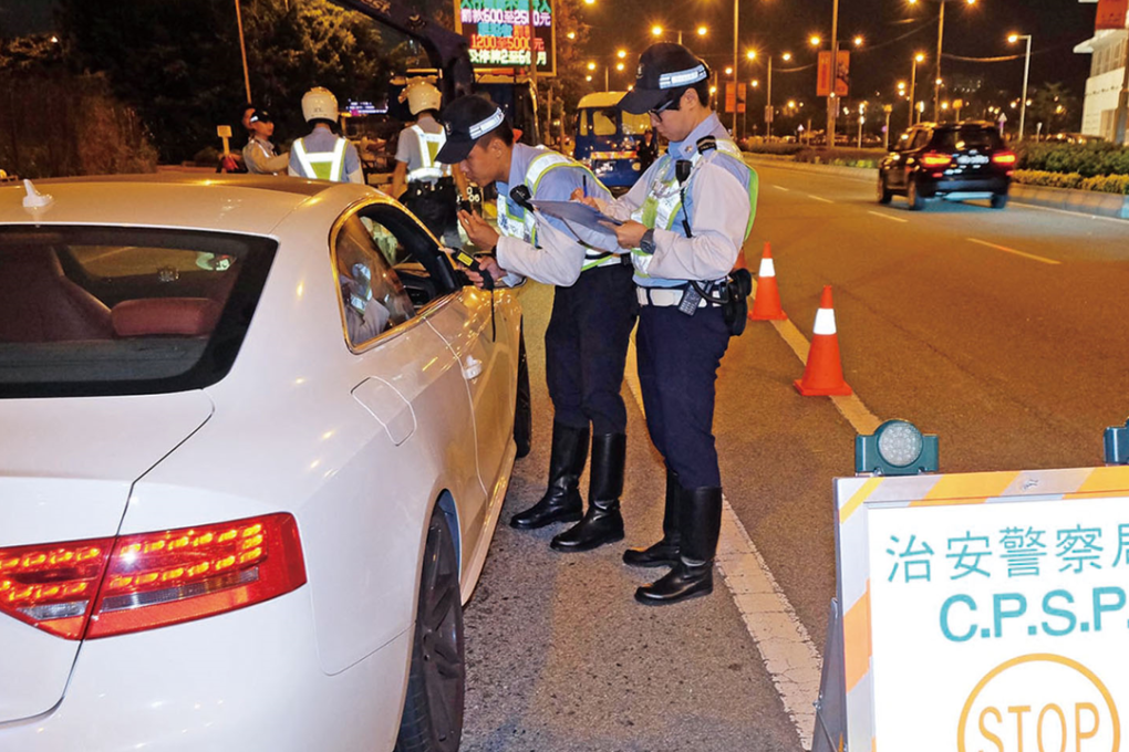 Macau police issuing a fine to an Uber driver. Photo: SCMP Pictures