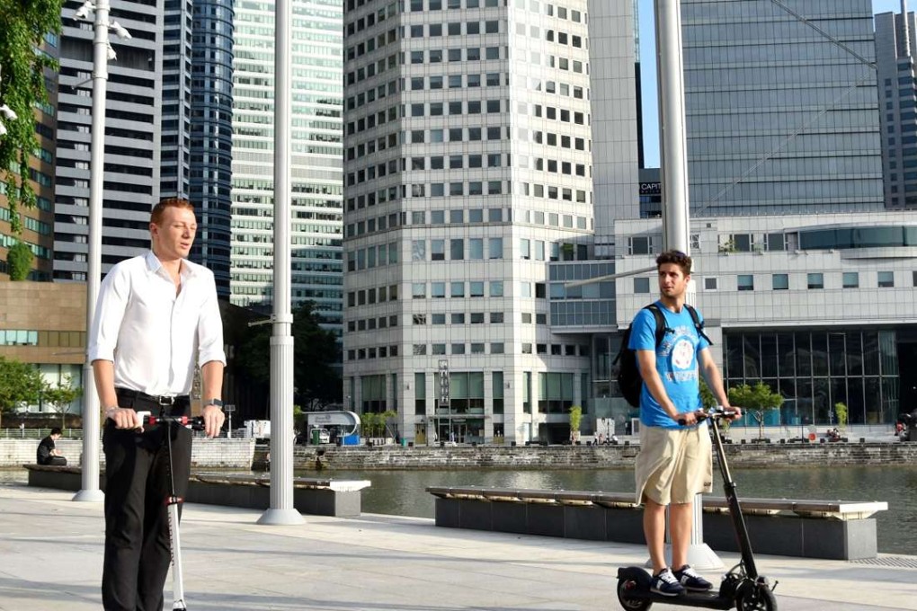People ride electric-powered scooters in central Singapore on July 27. Photo: Kyodo
