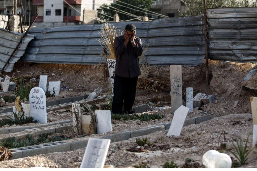 Abu Omar al-Ghoosh, a resident of Zamalka who lost 17 of his relatives in an apparent chemical attack, offers prayers for the victims on Sunday. Photo: AFP
