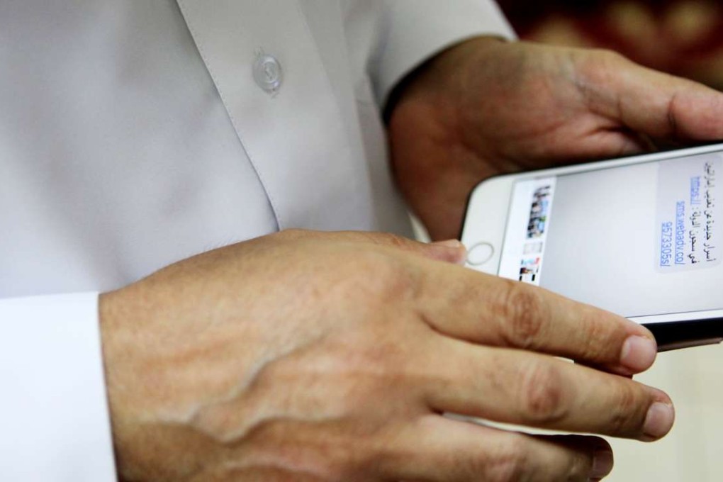 Ahmed Mansoor shows a screenshot of the hoax text message he received. Photo: AP