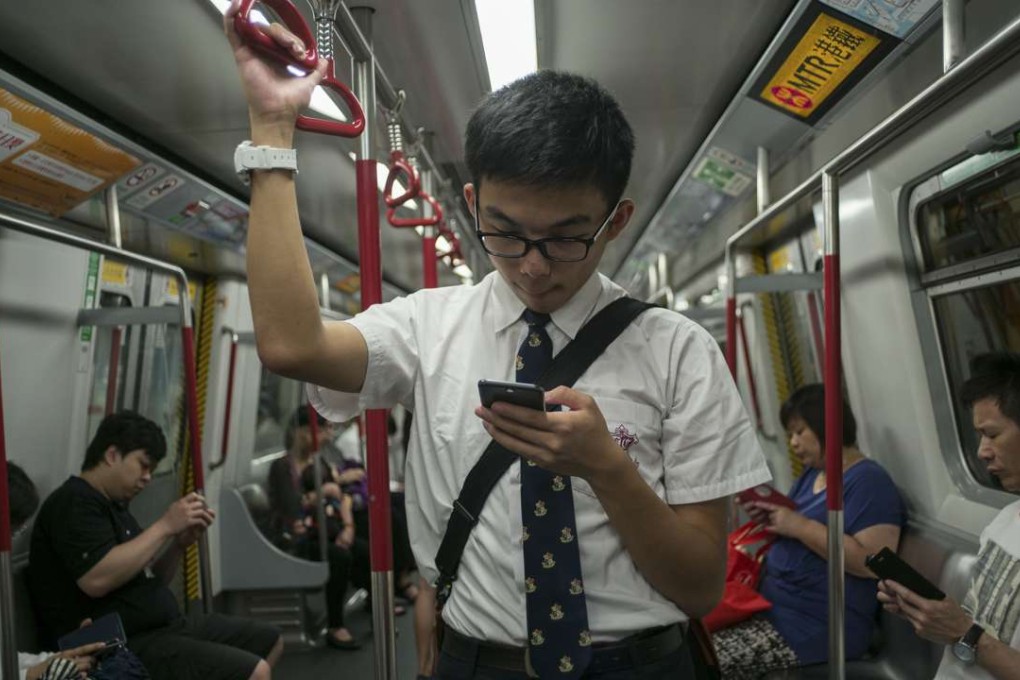 Passengers using their smartphones on the MTR. Hong Kong experiences far more than the average number of cyberattacks. Photo: AFP