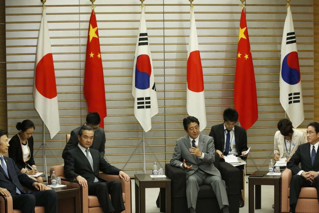 Japanese Prime Minister Shinzo Abe (second from right) meets South Korean Foreign Minister Yun Byung-Se (left), Chinese Foreign Minister Wang Yi (second from left) and Japanese Foreign Minister Fumio Kishida during their meeting at the prime minister's office in Tokyo on August 24, 2016. Photo: AFP