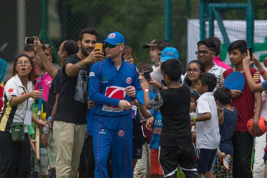 Fans take selfies with Michael Clarke of the Kowloon Cantons during the first Hong Kong T20 Blitz. Photo: AFP