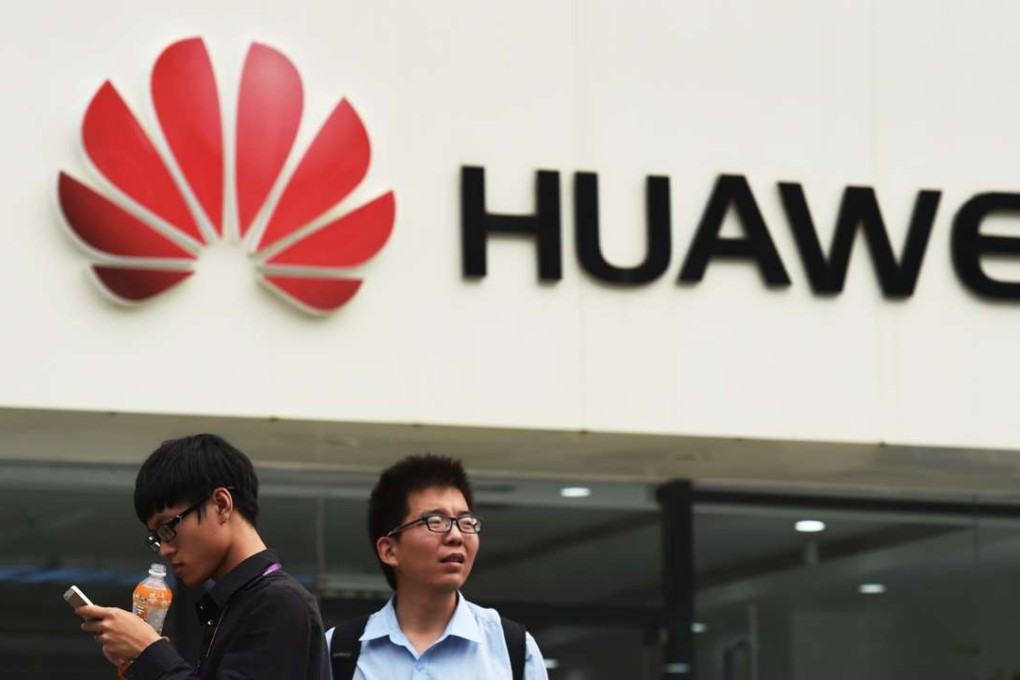 In this 2015 file photo, two men stand in front of a Huawei store in Beijing. The telecoms equipment giant took the No 1 spot in the All-China Federation of Industry and Commerce’s list of top 500 private businesses. AFP PHOTO / GREG BAKER / AFP PHOTO / GREG BAKER