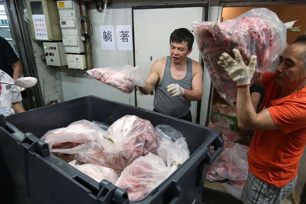 Government staff remove pork from Sheung Wan market after the latest food contamination scare. Photo: Nora Tam