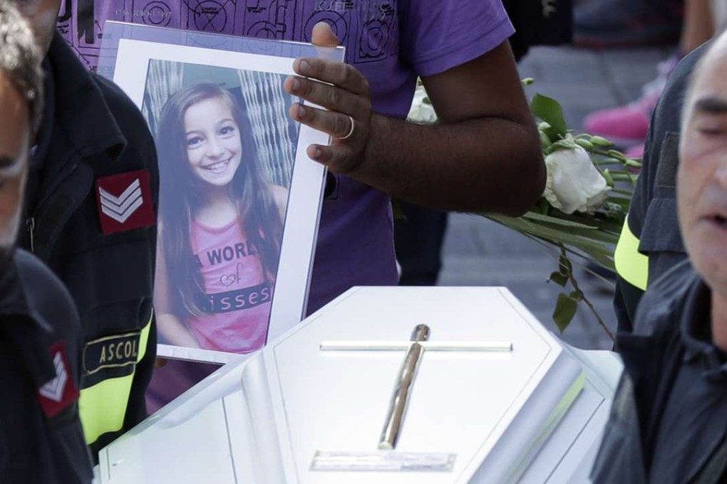 The coffin of 9-year-old Giulia Rinaldo, is carried outside the gymnasium at the end of the state funeral service in Ascoli Piceno. Photo: AP