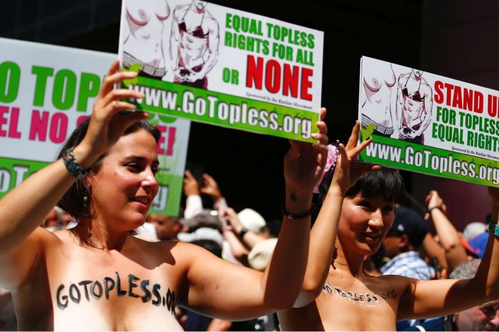 Activists hold posters as they take part in the Go Topless parade on Sunday in New York. Photo: AFP