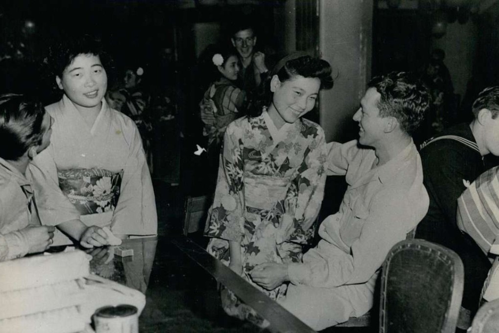 Soldiers and sailors mingle with their Japanese hostesses, in 1950s Tokyo. Picture: Alamy