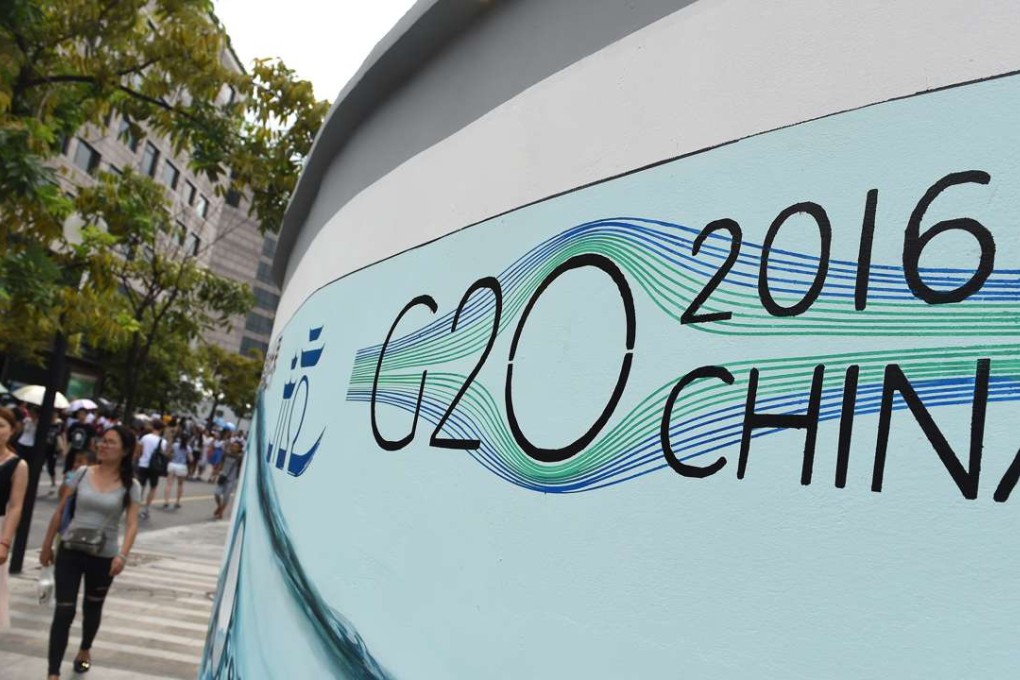 People walk past a G20 themed poster in Hangzhou. Photo: Xinhua