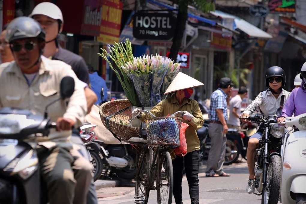 A street vender walks at a street in Hanoi, Vietnam as the country launches a rail modernisation programme which is being matched by other countries in Southeast Asia, sparking a commodities boom. Photo: EPA
