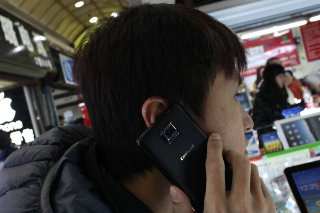 A man seen using a Coolpad smartphone in Shanghai. The company expects the mainland smartphone market will improve in the second half of 2016. Photo: Reuters
