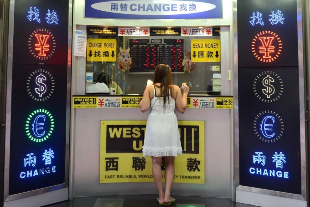 A money exchange booth in Hong Kong. The PBOC on Wednesday set the yuan reference point against the US dollar at 6.6908, 98 basis points or 0.15 per cent weaker than on Tuesday. Photo: Antony DICKSON