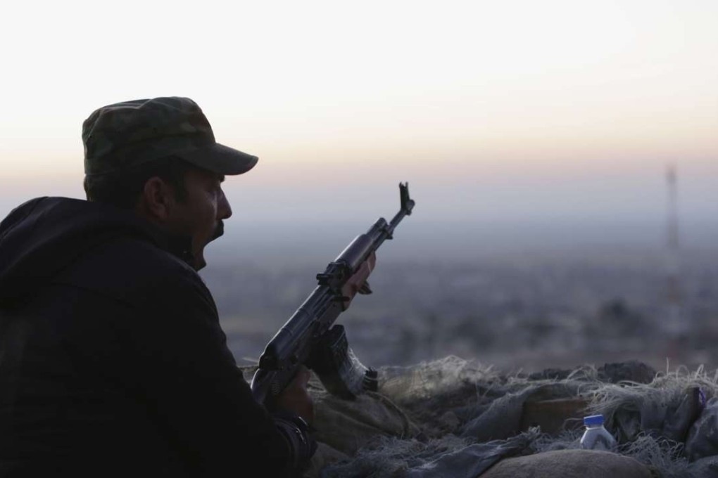 A Kurdish fighter, known as a peshmerga, yawns as he stands guard on the frontline. Photo: AP