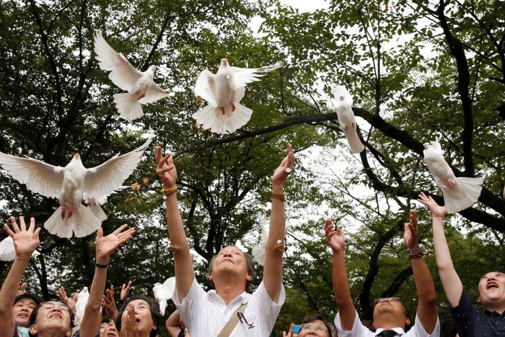 People release doves as a symbol of peace at the Yasukuni Shrine in Tokyo, in August 2016, to mark the anniversary of the end of the second world war. Photo: Reuters