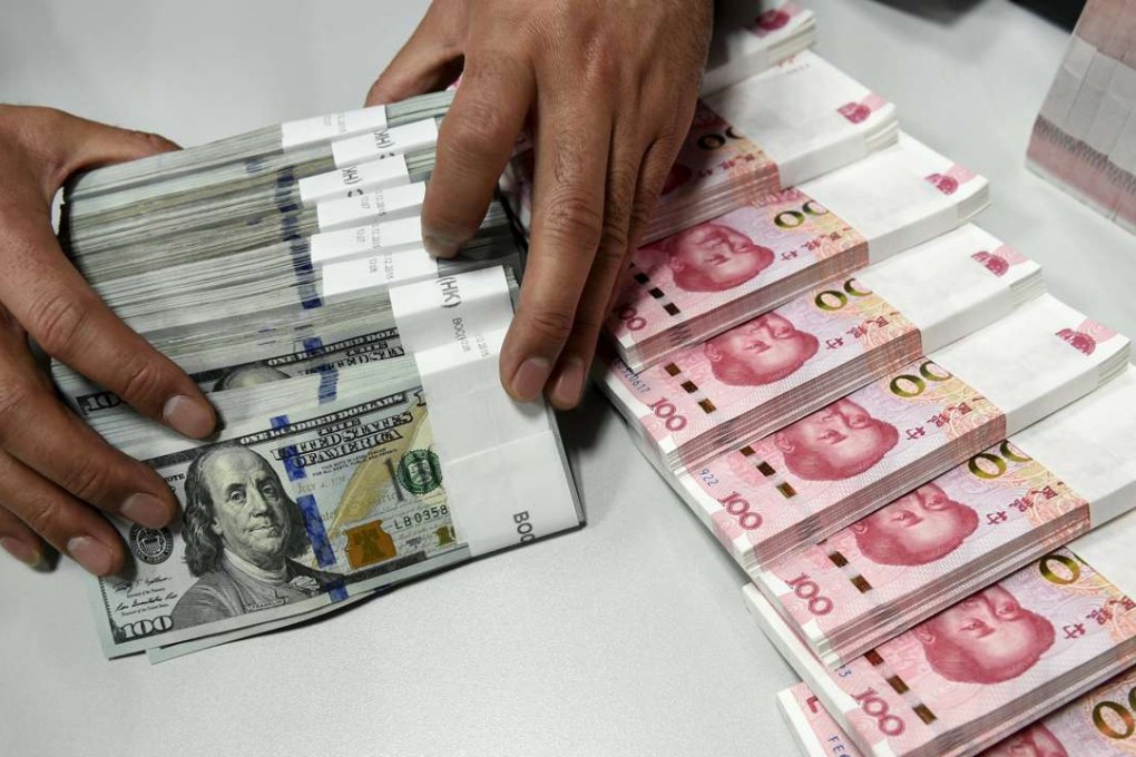A clerk counts Chinese yuan and US dollar banknotes at a bank in China. Photo: Reuters