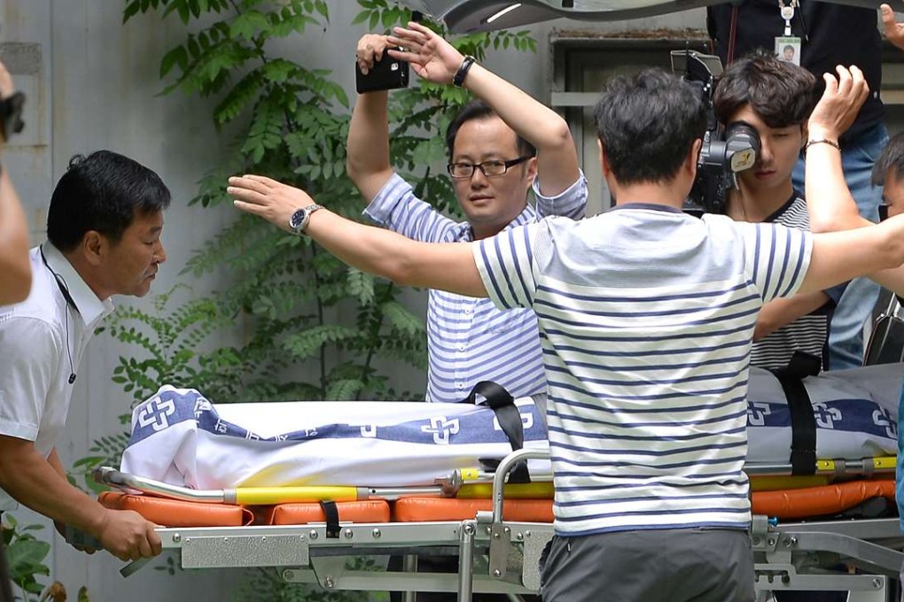 The body of Lotte Group vice-chairman Lee In-won is wheeled into an ambulance in Yangpyeong, South Korea, on August 26, 2016. Photo: Reuters