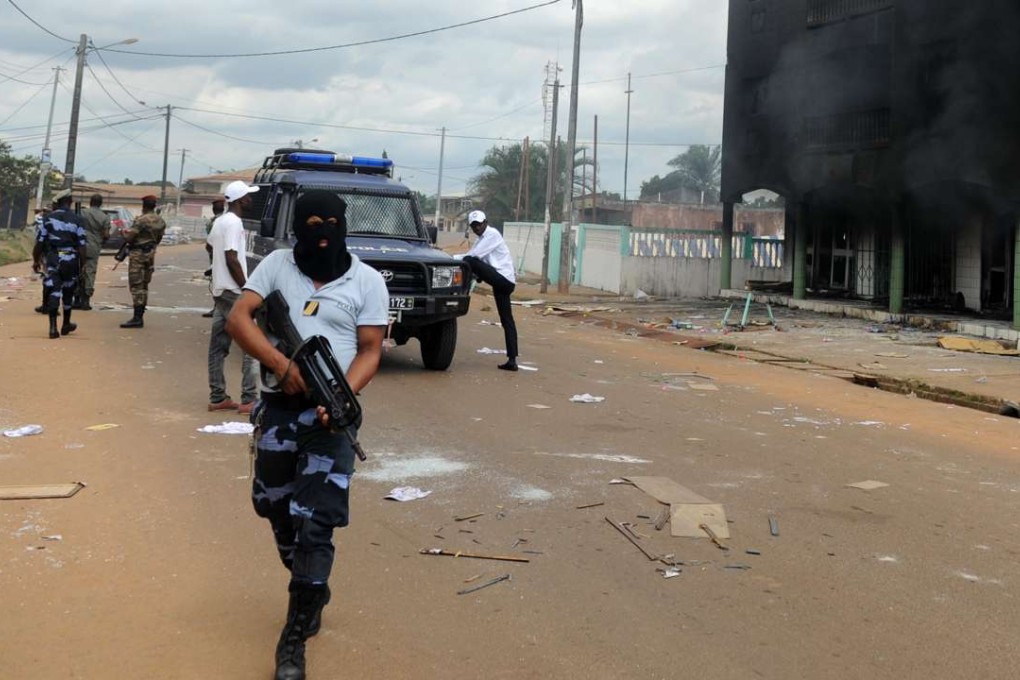Gabonese Police stand guard at a barricade following an election protest in Libreville, Gabon, on Tursday. Photo: AP