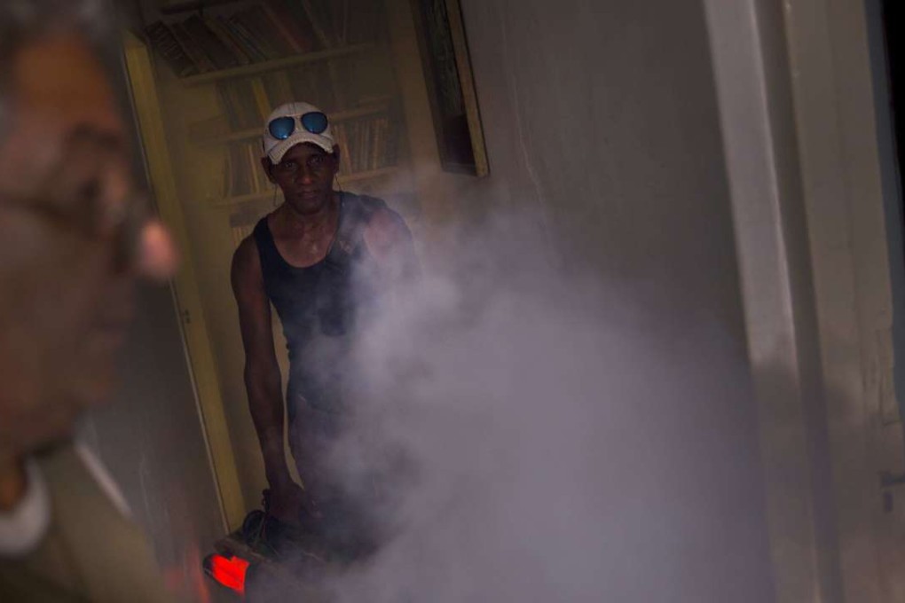 A government fumigator sprays a home for mosquitos in Havana, Cuba, on August 26. Photo: AP