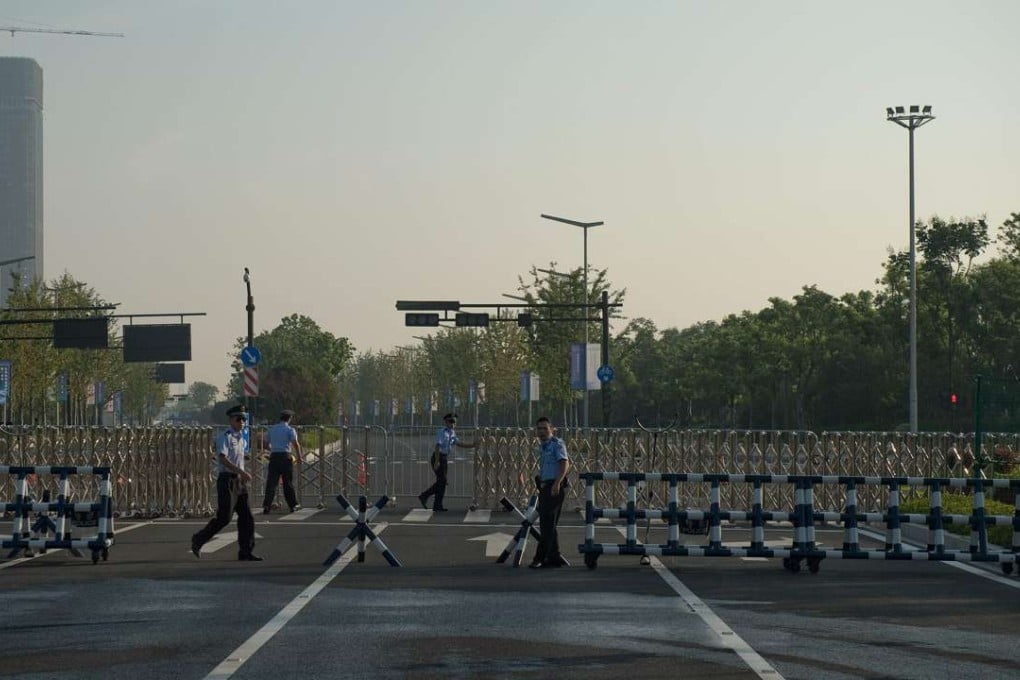Chinese security guards open a gate leading to the G20 media centre in Hangzhou on Saturday, which begins on Sunday. Photo: AFP