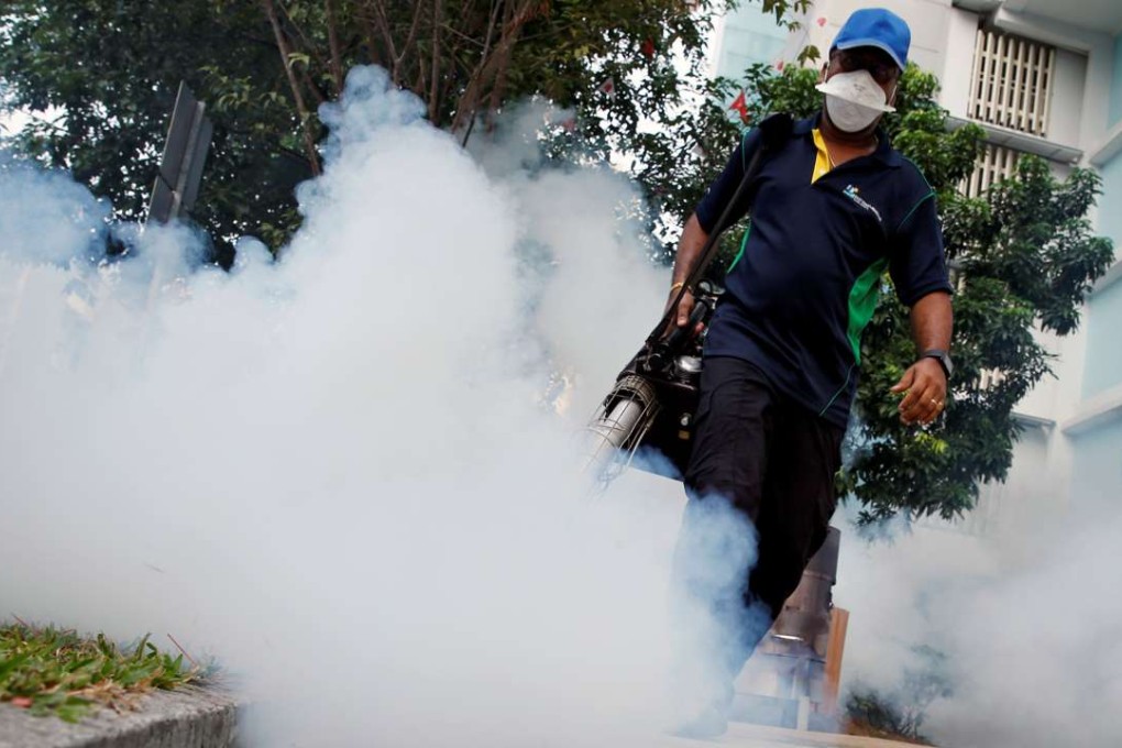 A worker sprays the common area of a housing estate in Singapore as part of the campaign against Zika. Photo: Reuters