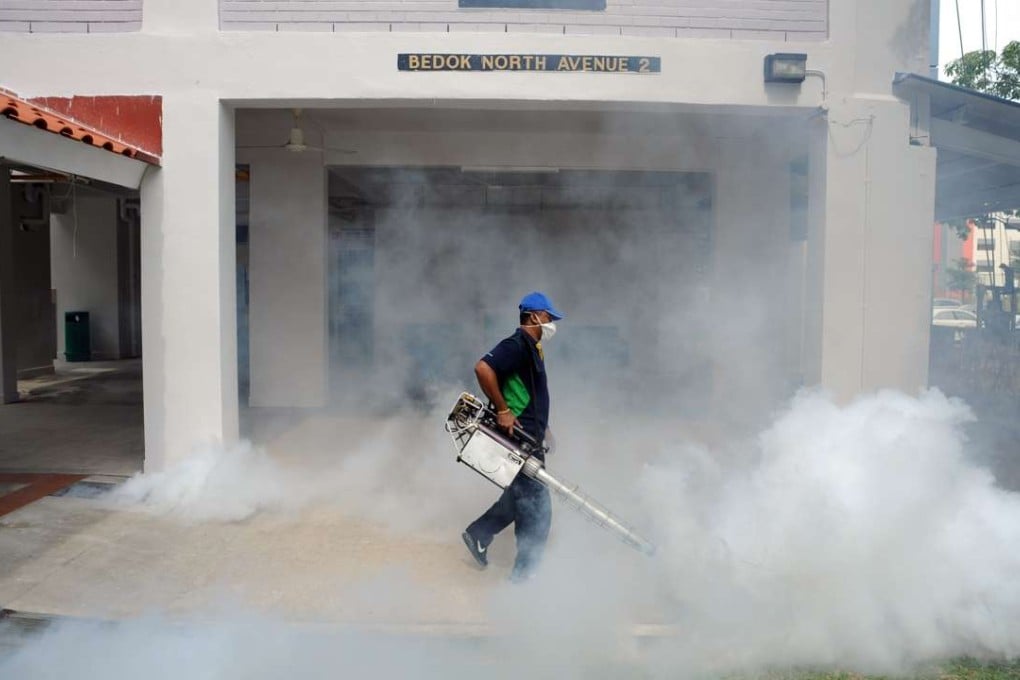 A worker sprays insecticide at a residential area in Singapore. Photo: Xinhua