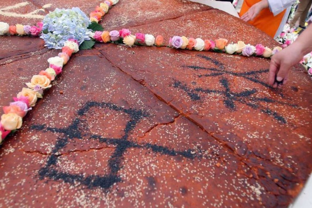 The huge mooncake baked in the city of Kunming has four Chinese characters, Zhong Qiu Kuai Le, meaning Happy Mid-Autumn Day, written on the crust. Photo: SCMP Pictures