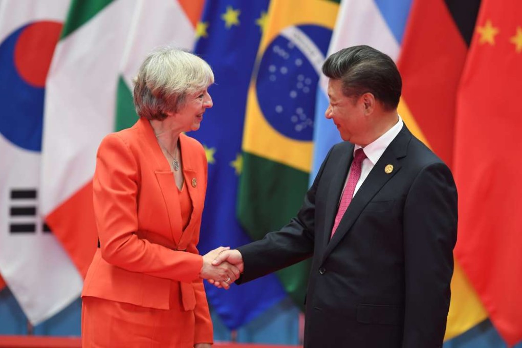 British Prime Minister Theresa May shakes hands with President Xi Jinping on Sunday. Photo: AFP