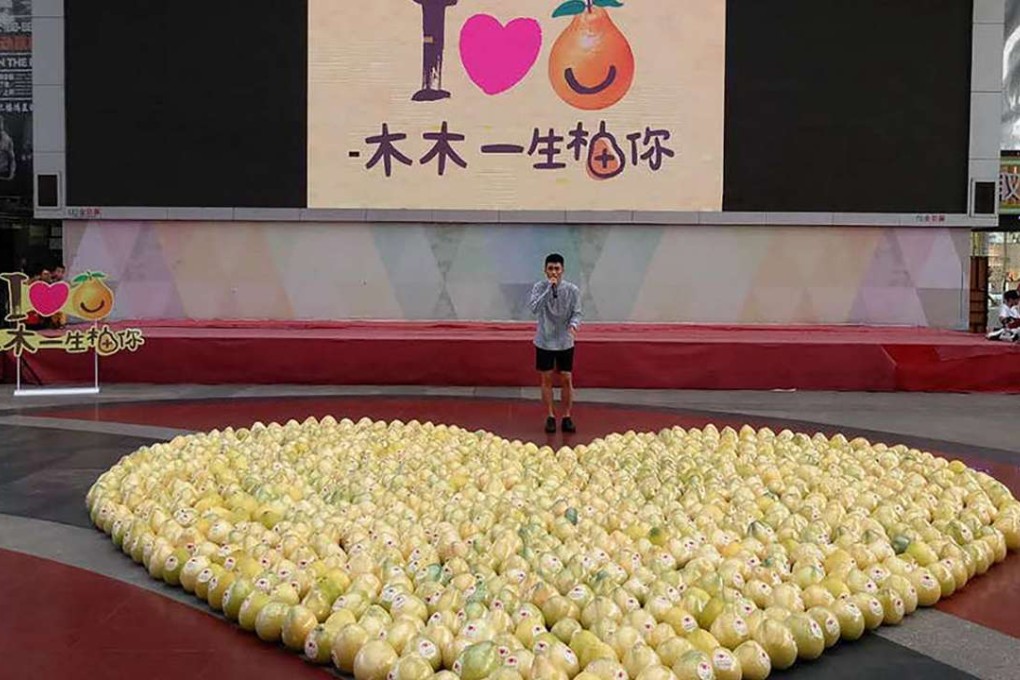 The would-be Romeo with his display of pomelos. Photo: QQ.com