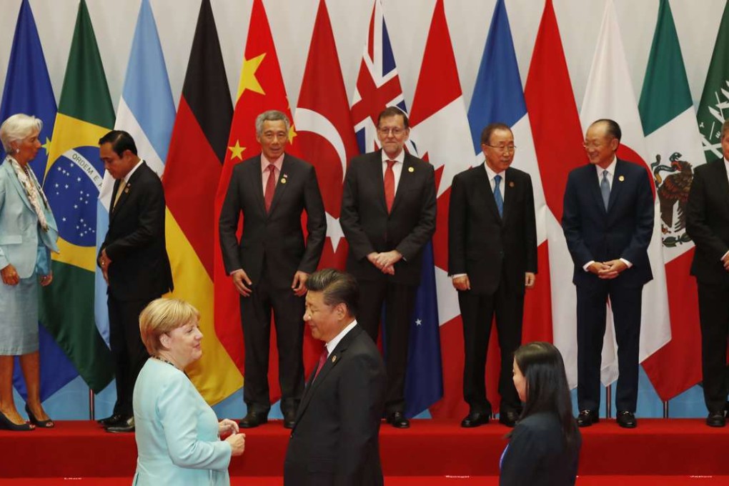 German Chancellor Angela Merkel, foreground left, chats with President Xi Jinping as other leaders stand on stage waiting for a group photo session for the G20 summit in Hangzhou. Photo: AP