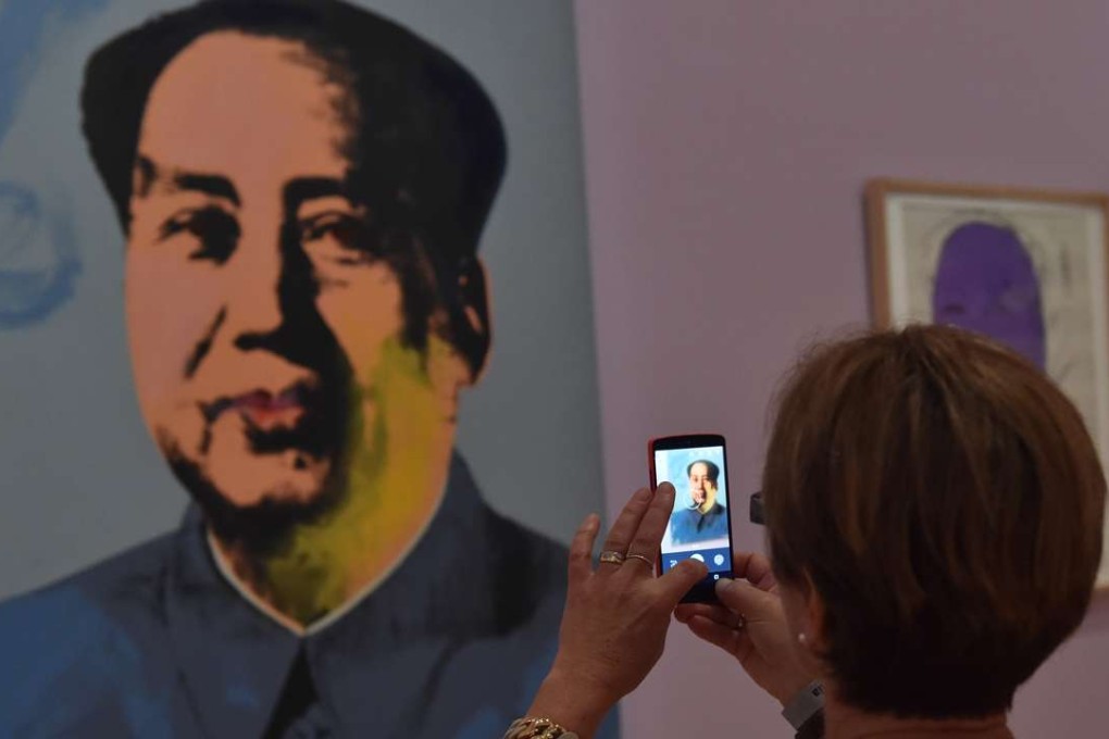 A woman in Melbourne takes a picture of a portrait of Mao Zedong by Chinese dissident artist Ai Weiwei. Photo: AFP