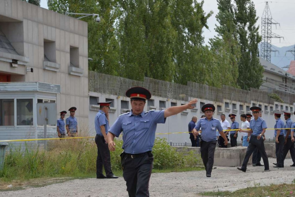 Kyrgyz police officers clear the area outside the Chinese embassy in Bishkek after a suspected suicide bomber rammed his vehicle through a gate and blew himself up on August 30. Three people were wounded. Photo: AFP
