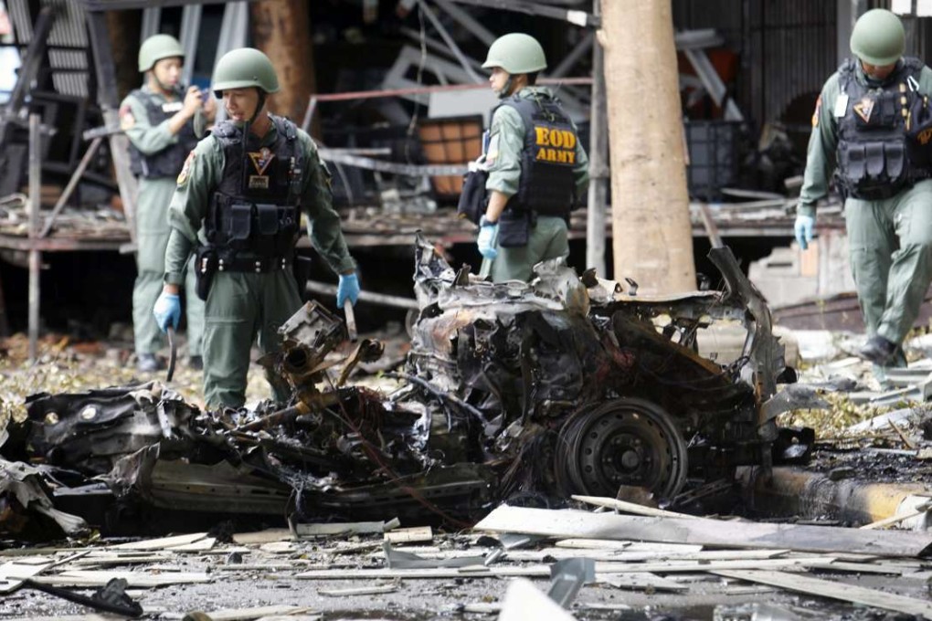 Members of the Thai Explosive Ordnance Disposal squad inspect the wreckage of vehicles after a car bomb attack at a hotel in Pattani, southern Thailand, on 24 August. Photo: EPA