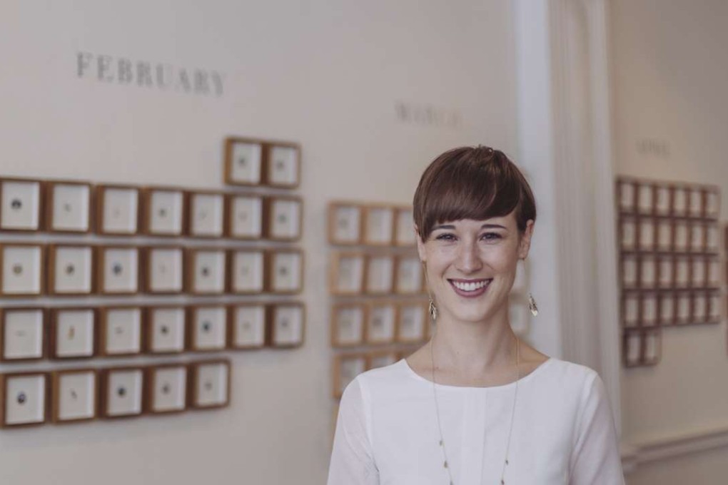 South African painter Lorraine Loots poses in front of a display of her miniatures.