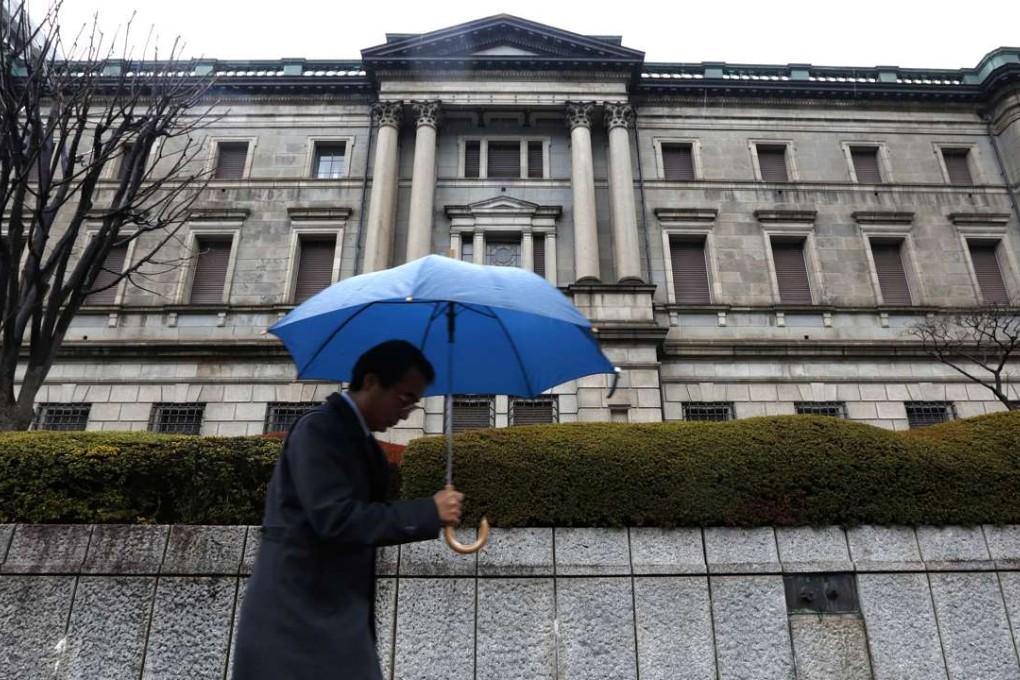 A pedestrian walks past the Bank of Japan headquarters in Tokyo. Photo: Bloomberg