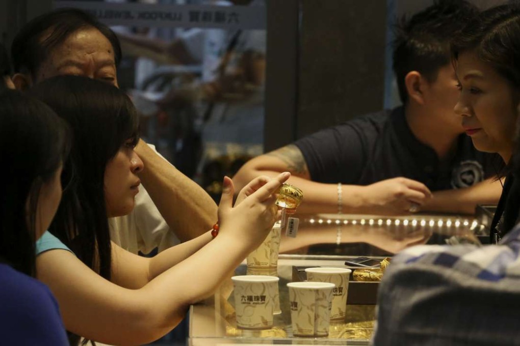Customers choose gold accessories at a gold store in Causeway Bay on July 19, 2015. Photo: Felix Wong
