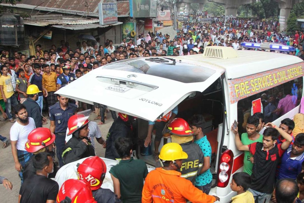Firefighters carry a victim to an ambulance after the explosion in the Tongi factory. Photo: EPA