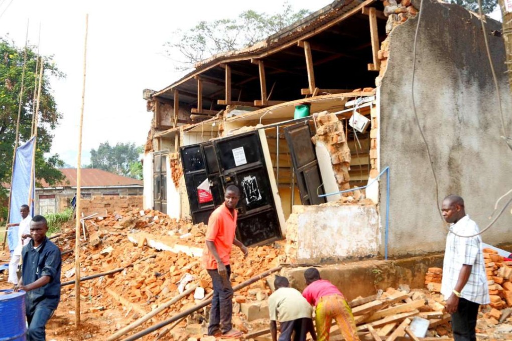 People remove wreckage of a house damaged following an earthquake measured 5.7 magnitude which struck the country’s Lake Zone in Bukoba, northwest Tanzania, on September 10, 2016. The 10 km depth quake left 14 people dead and more than 200 people injured some of them seriously, according to Bukoba District Commissioner, Deodatus Kinawilo. / AFP PHOTO / STR