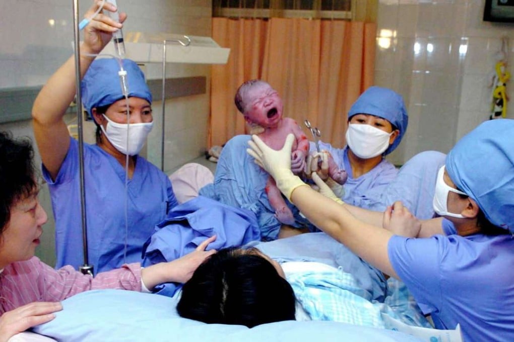 Medical staff hold a newborn baby boy at a hospital in Beijing. The relaxation of the one-child policy is adding to demand for hospital beds in some Chinese cities. Photo: Xinhua