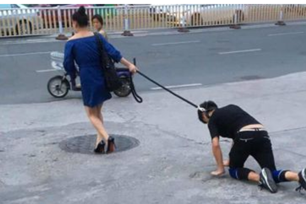The Chinese woman caused a traffic jam as she led the man on his hands and knees in Fujian province, during Friday evening’s rush hour. Photo: SCMP Pictures